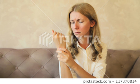 Unhealthy young woman suffers from wrist pain, tunnel syndrome, unwell girl touching her hand Unhealthy young woman suffers from wrist pain, tunnel syndrome, unwell girl touching her hand 117370814