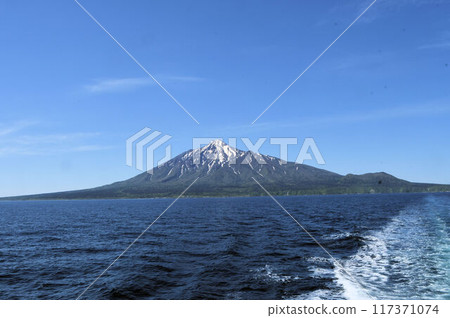 從利尻島出發的渡輪上可以看到利尻富士，殘雪美麗，藍天白雲下，前方有浪花的條紋 117371074