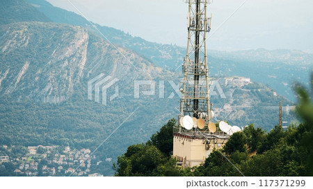 5G telecommunication tower against the French Alps mountains and historic Bastille fortress in Grenoble 117371299