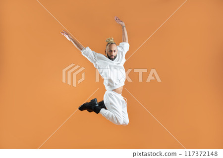 Gay man dancing isolated on orange Gay man dancing isolated on orange 117372148