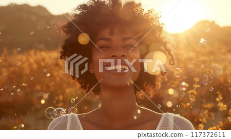 Cheerful woman elegantly blows colorful bubbles in an outdoor setting under the radiant sun 117372611