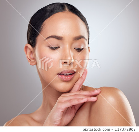 Her beauty catches everyones attention. Studio shot of a beautiful young woman posing against a grey background. 117372902