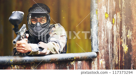 Paintball, gun and war with a sports man playing a military game for fun or training outdoor. Camouflage, soldier and target with a male athlete shooting a weapon outside during an army exercise 117373294