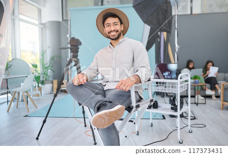 Portrait, happy and photographer in studio for photo shoot, relax and confident in professional setup. Face, asian male and magazine photography, backstage and proud while posing, smile and casual 117373431