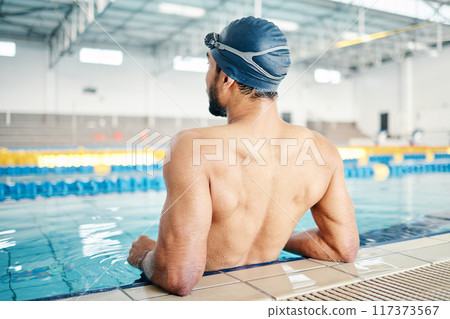 Swimming cap, pool and back of a man preparing for competition, exercise or training in a pool. Sports, fitness and professional male swimmer standing ready for water workout, challenge or sport race 117373567