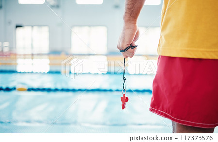 Hands, lifeguard and whistle by swimming pool for water safety, security or ready for rescue indoors. Hand of expert swimmer holding signal tool for warning, safe swim or responsibility for awareness Hands, lifeguard and whistle by swimming pool for water safety, security or ready for rescue indoors. Hand of expert swimmer holding signal tool for warning, safe swim or responsibility for awareness 117373576