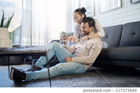 Interracial, couple and people with phone on social media laughing at meme or funny internet content. Man, woman and lovers relax in home, house or apartment browsing the web, website or app Interracial, couple and people with phone on social media laughing at meme or funny internet content. Man, woman and lovers relax in home, house or apartment browsing the web, website or app 117373690