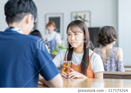 Young woman getting angry at her boyfriend in a cafe 117374204