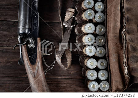 double barreled side shotgun with cartridges in bandolier. 117374258