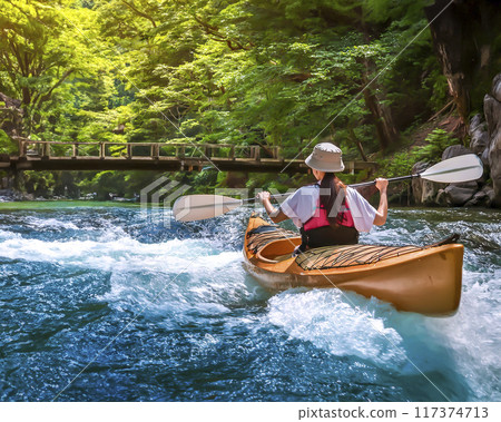 Image of a woman enjoying kayaking in a clear stream 117374713