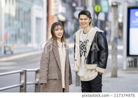 Smiling young man and woman looking at camera 117374978