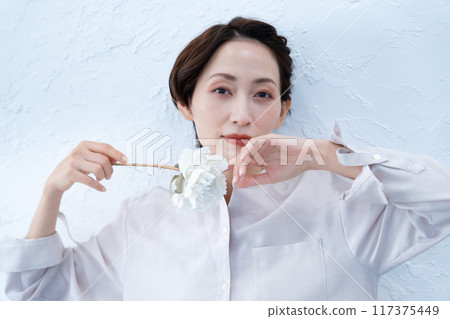 Middle-aged woman holding a white rose 117375449