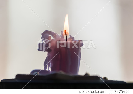 Burning candle in the shape of a unicorn on a dark background Burning candle in the shape of a unicorn on a dark background 117375693