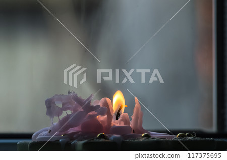 Burning candle on a window sill, close-up, selective focus Burning candle on a window sill, close-up, selective focus 117375695