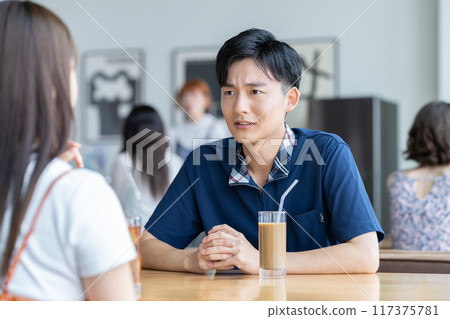 Young man apologizing to his girlfriend in a cafe Young man apologizing to his girlfriend in a cafe 117375781