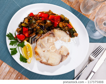 Scandinavian cuisine seafood served with fried vegetables on plate on wooden table 117375808