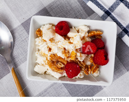 Farm cottage cheese filled with large amount of honey with walnut and raspberry. Farm cottage cheese filled with large amount of honey with walnut and raspberry. 117375950