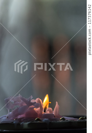 Burning candle in the dark. Shallow depth of field. 117376142