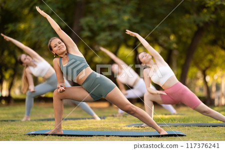 Group of young women doing stretching in park 117376241
