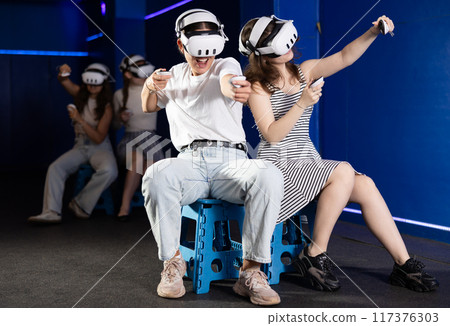 Two girls competing in team-based virtual reality game Two girls competing in team-based virtual reality game 117376303