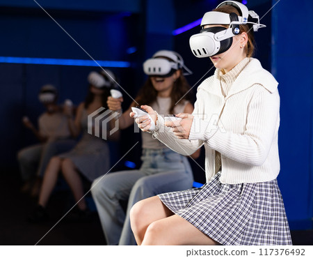 Girls using virtual reality glasses - girlfriends having fun with vr headset Girls using virtual reality glasses - girlfriends having fun with vr headset 117376492