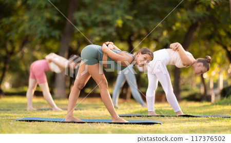 Group of young women doing yoga in park Group of young women doing yoga in park 117376502
