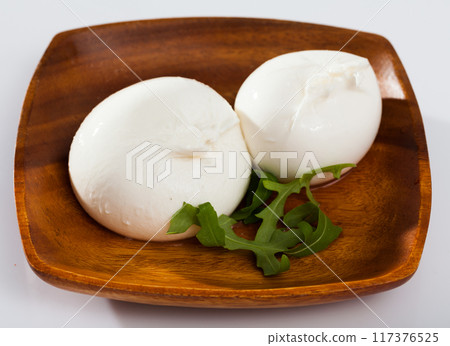 Burrata italian cheese and arugula green leaf at wooden plate 117376525