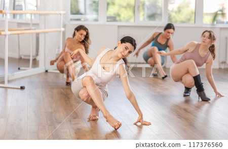 Dancing training in high heels for slender beautiful women in dance studio Dancing training in high heels for slender beautiful women in dance studio 117376560