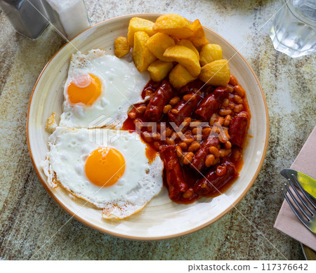 Full English breakfast with eggs, sausages, beans, and fries Full English breakfast with eggs, sausages, beans, and fries 117376642