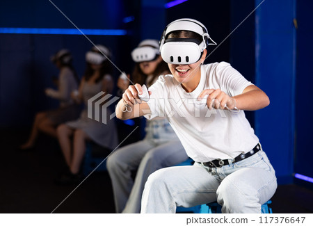 Excited young girl playing virtual reality game 117376647