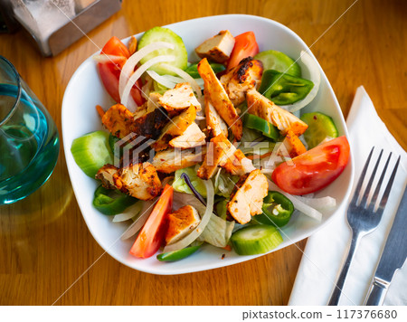 Chicken salad with fresh vegetables on table in restaurant Chicken salad with fresh vegetables on table in restaurant 117376680