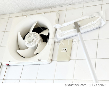 Clean the tile wall next to the ventilation fan with a floor mop Clean the tile wall next to the ventilation fan with a floor mop 117377028