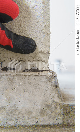 Close-up of a worker inspecting the deterioration of exterior wall joints Close-up of a worker inspecting the deterioration of exterior wall joints 117377555