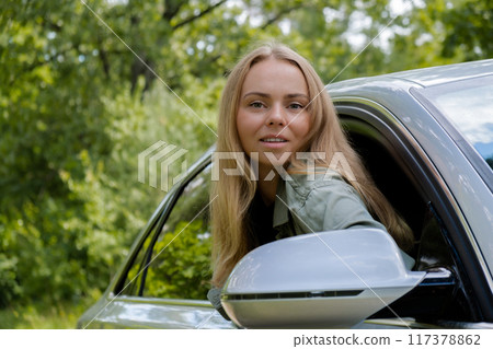 Blonde woman sticking head out of windshield car. Young tourist explore local travel making candid real moments. True emotions expressions of getting away and refresh on open clean air 117378862