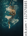 Woman in a white dress underwater as if in zero gravity 117378885