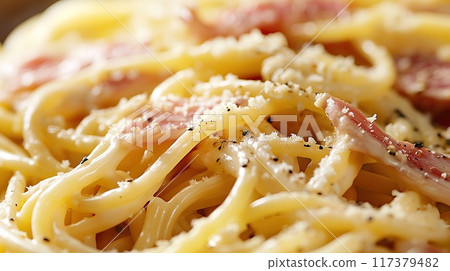 Close-up of a plate of spaghetti carbonara topped with crispy pancetta, grated cheese, and fresh parsley, ready to serve.. Close-up of a plate of spaghetti carbonara topped with crispy pancetta, grated cheese, and fresh parsley, ready to serve.. 117379482