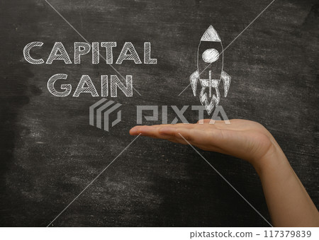 A hand holding a chalkboard with the word Capital Gain written on it 117379839