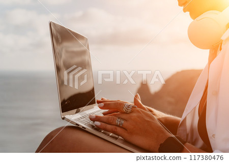 Woman sea laptop. Business woman, freelancer with laptop working over blue sea beach. Happy smiling girl relieves stress from work. Freelance, remote work on vacation, digital nomad, travel concept Woman sea laptop. Business woman, freelancer with laptop working over blue sea beach. Happy smiling girl relieves stress from work. Freelance, remote work on vacation, digital nomad, travel concept 117380476