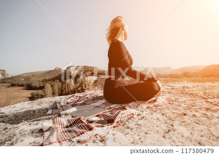 Woman Meditating on a Mountaintop 117380479