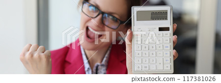 Excited business woman in the office showing one million number on calculator 117381026