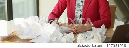 Serious concentrated business woman writing, crumpled paper on table Serious concentrated business woman writing, crumpled paper on table 117381028