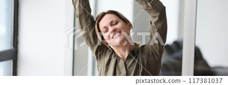 Happy woman manager raising hands up and celebrating victory in office 117381037