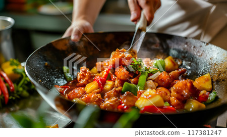 Asian Chef Preparing Sweet and Sour Chicken in a Wok 117381247