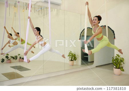 Practicing Aerial Yoga in Modern Spacious Studio 117381810