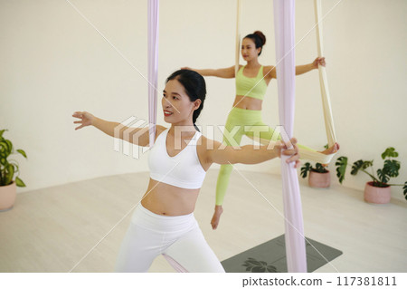 Exercising with Aerial Silk in Fitness Studio 117381811