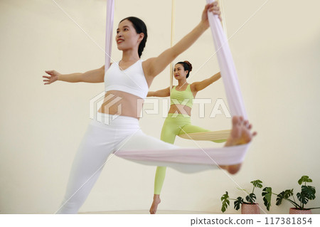Practicing Aerial Yoga on Suspended Silk Hammocks Practicing Aerial Yoga on Suspended Silk Hammocks 117381854