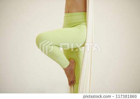 Practicing Aerial Yoga Poses with Suspended Silk 117381860