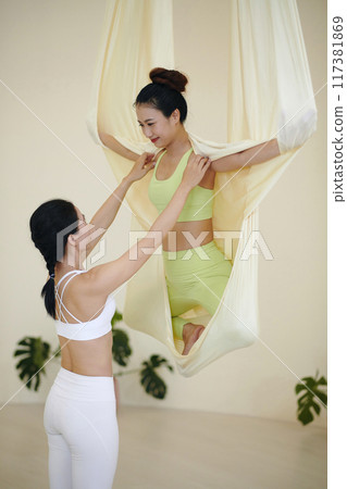 Practicing Aerial Yoga with Assistance for Balance and Stability 117381869