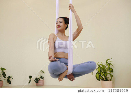 Practicing Aerial Yoga Poses with Calm Expression Practicing Aerial Yoga Poses with Calm Expression 117381929
