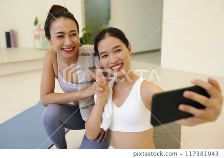 Smiling Friends Taking Selfie During Yoga Session in Studio Smiling Friends Taking Selfie During Yoga Session in Studio 117381943